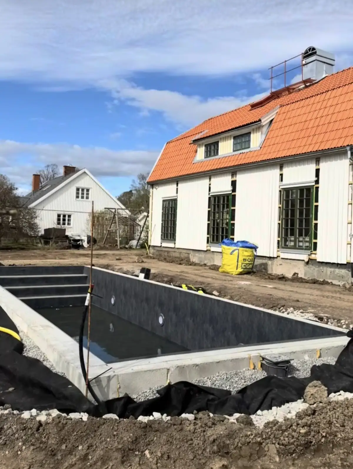 Färdigmonterad pool med liner vid villa i Täby, invid huset under renovering