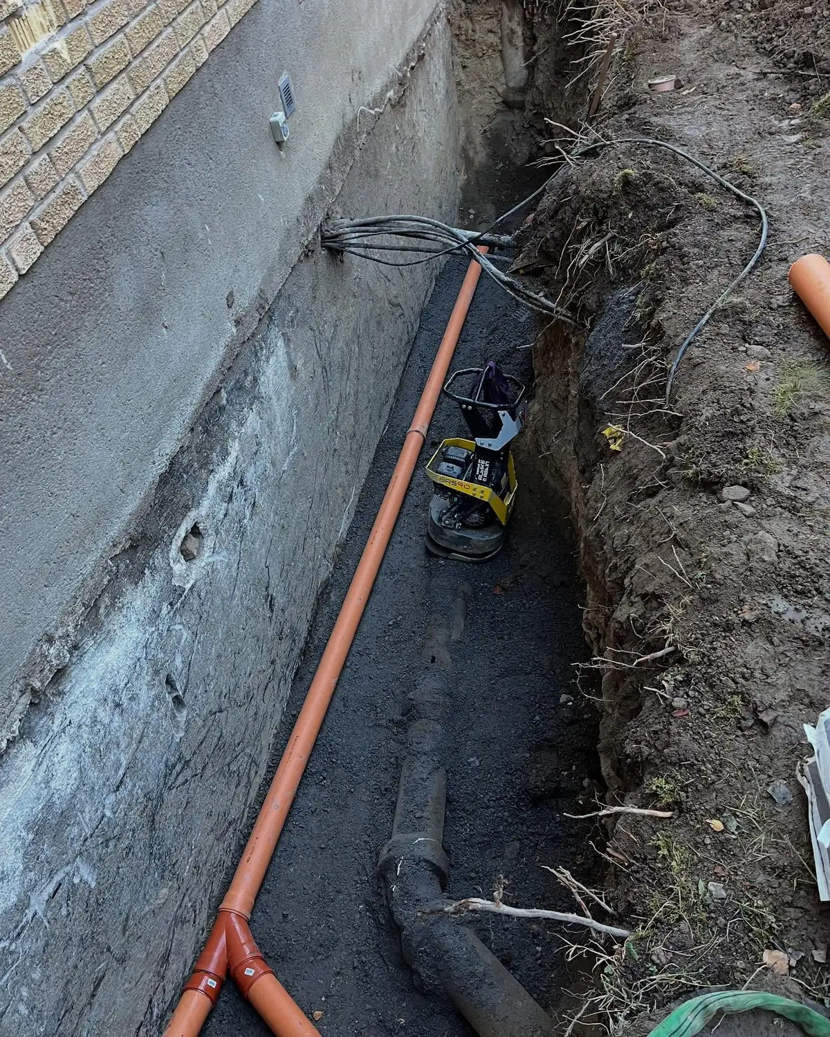 Installation av dagvattenledning och dränering vid husgrund
