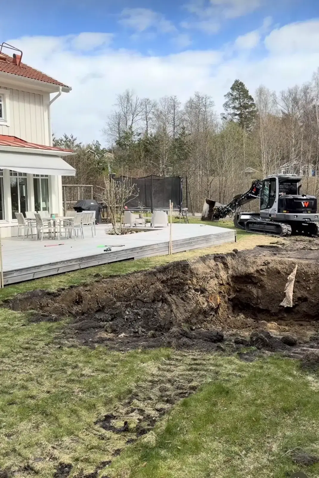 Poolschakt vid villa i Täby — grävmaskin gräver ur poolgropen