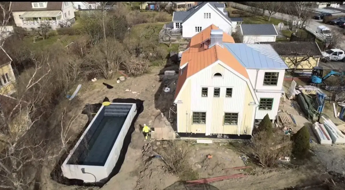Färdig nedgrävd pool vid villa i Täby — flygbild över poolen och huset efter markarbete
