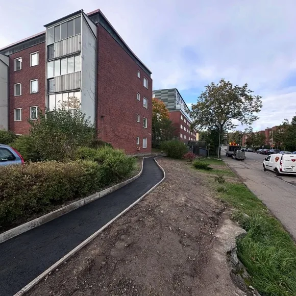 Färdig asfalterad gångväg vid flerbostadshus