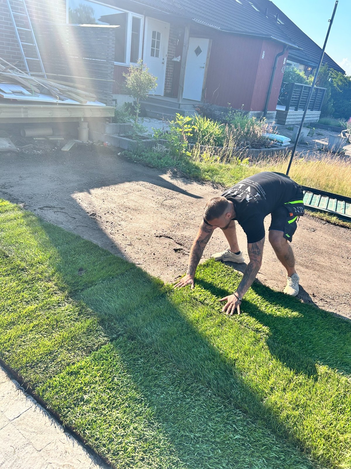 Niback-medarbetare lägger ut färdig gräsmatta vid villa i Åkersberga