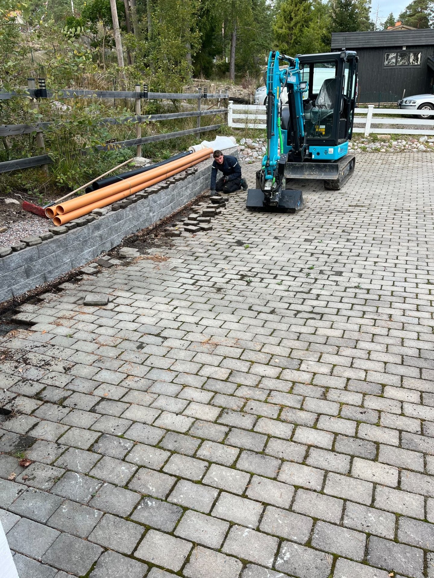 Stenlagd uppfart vid villa i Sollentuna under omläggning med grävmaskin